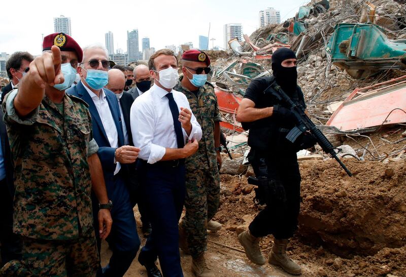 French President Emmanuel Macron surrounded by Lebanese servicemen, visits the devastated site of the explosion at the port of Beirut. AFP