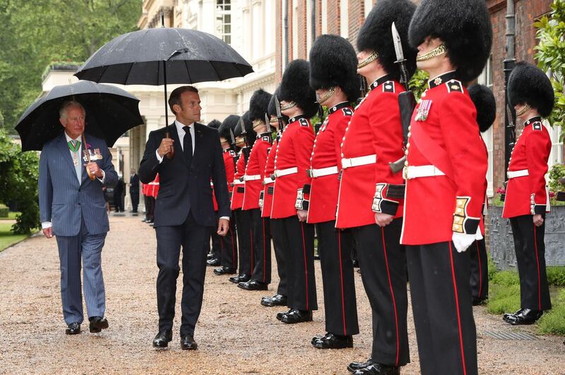 Britain's Prince Charles and French President Emmanuel Macron inspect a guard of honour from the Grenadier Guards at Clarence House in central London. AFP