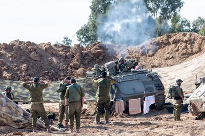 An armoured vehicle fires as soldier's cover their ears on Tuesday in Beeri, Israel. Getty 