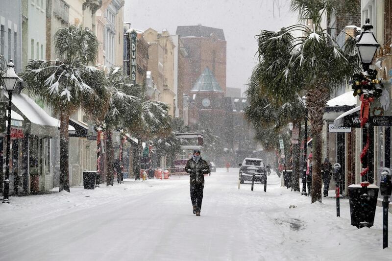 A person walks in the snow on King Street in Charleston, S.C., Wednesday, Jan. 3, 2018. A brutal winter storm smacked the coastal Southeast with a rare blast of snow and ice Wednesday, hitting parts of Florida, Georgia and South Carolina with their heaviest snowfall in nearly three decades. (Matthew Fortner/The Post And Courier via AP)