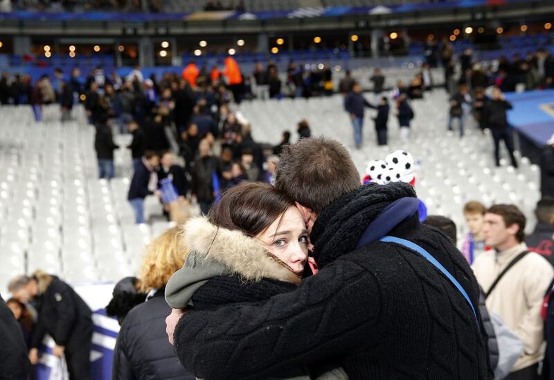 A man comforts a woman after spectators poured onto the pitch of the Stade de France stadium after multiple explosions outside. Christophe Ena/AP Photo