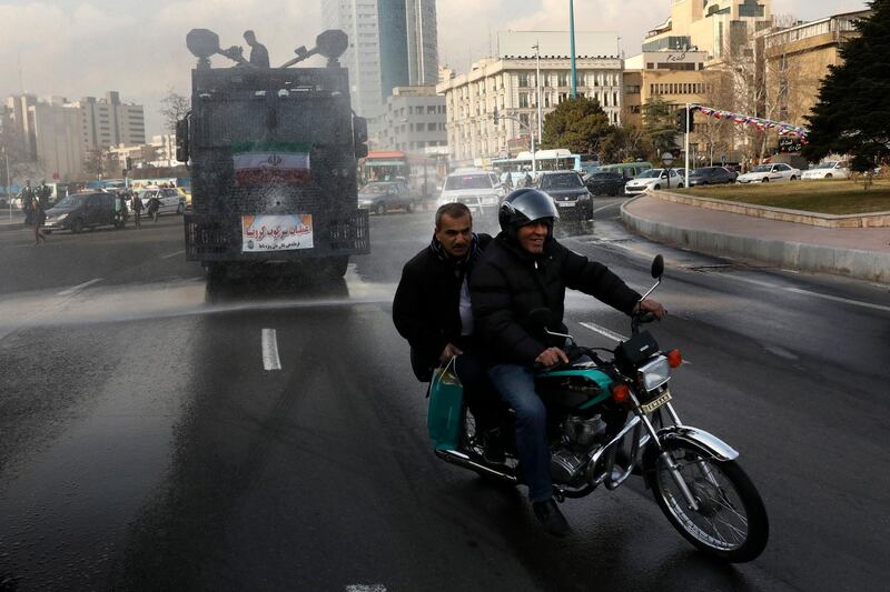 A police vehicle disinfects streets against the coronavirus, in Tehran, Iran. AP Photo