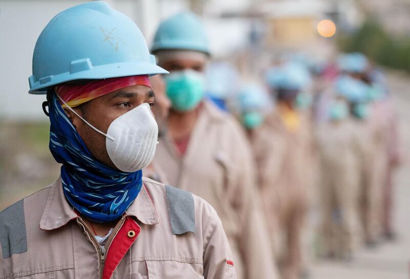 Labourers wear protective face masks as they wait in line to get temperature checked before entering construction worksite, following the outbreak of the coronavirus disease (COVID-19), in Ahmadi, Kuwait. Reuters