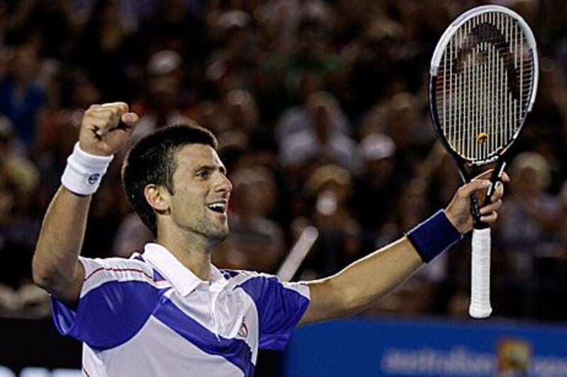 Serbia's Novak Djokovic raises his arms in celebration after clinching his second grand slam title.