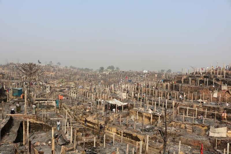 Rohingya refugees stand at the site of Monday's fire at a Rohingya refugee camp in Balukhali, southern Bangladesh. AP Photo