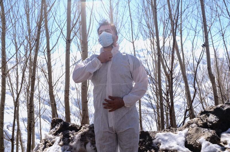 Doctor Sergan Saracoglu puts on a suit of personal protective equipment before entering the village of Guneyyamac in eastern Turkey on February 15, 2021. AFP