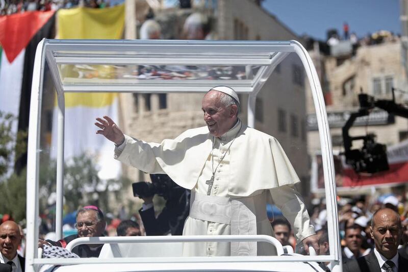 Pope Francis waves to the crowd as he arrives to lead an open-air in the Manger Square, next to the Nativity Church in the West Bank town of Bethlehem May 25. 2014. Pope Francis made an impassioned plea for peace on a pilgrimage on Sunday to Bethlehem, the traditional birthplace of Jesus, urging an intensified effort to end the Israeli-Palestinian conflict. Fadi Arouri/Reuters