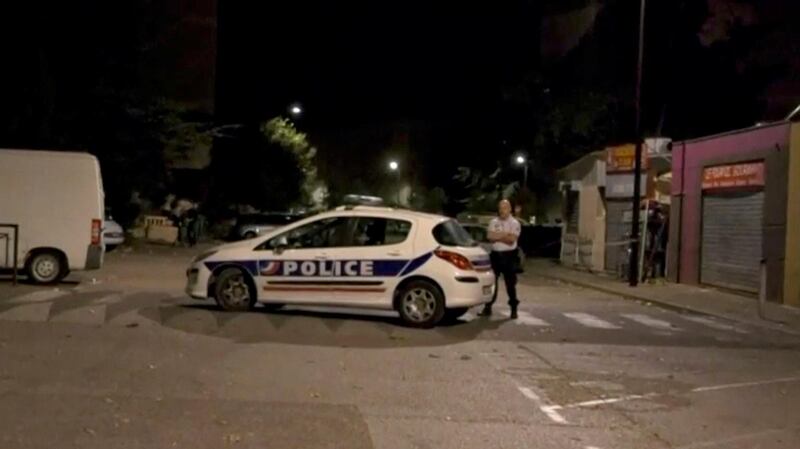 A police officer stands guard on a street near a scene of a shooting in front of a mosque in Avignon