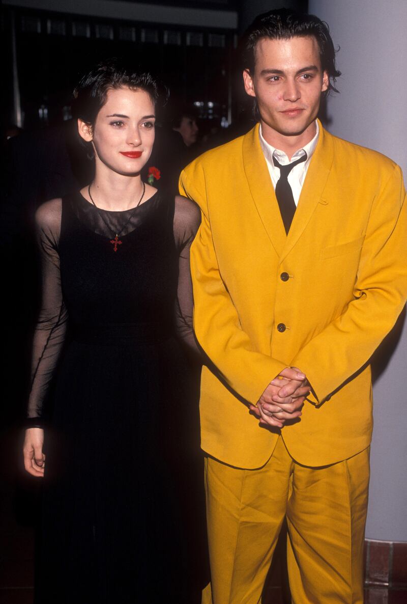 Winona Ryder, in a black dress with opaque sleeves, is joined by Johnny Depp at the 'Cry Baby' premiere on July 1, 1990. Getty