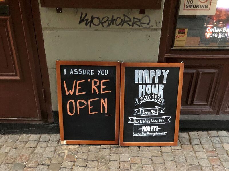 FILE PHOTO: A sign assures people that the bar is open during the coronavirus outbreak, outside a pub in Stockholm, Sweden March 26, 2020. Picture taken March 26, 2020. REUTERS/Colm Fulton/File Photo