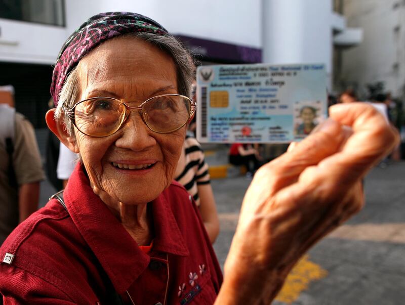 Thai 92-year-old voter Somcuan Rumpikul shows her citizen identity card as she lines up to cast her ballot at a polling station during the general election in Bangkok. EPA
