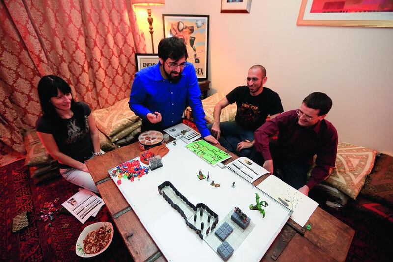 Game on: left to right, Alesya Katyuk, Omar Ismail, Tarek Omar and Thomas Martin – all members of the highly social, 220-person-strong Gulf Roleplaying Community – get down to role-playing business in Abu Dhabi. Sarah Dea / The National



