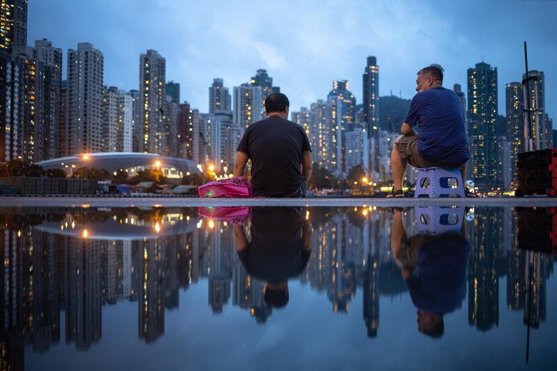 epa08471047 Fishermen are reflected in a puddle in Hong Kong, China, 07 June 2020.  EPA/JEROME FAVRE