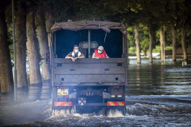 Residents are transported through the high water of the Meuse between Bergen and Nieuw, with the help of a shuttle service operated by the Dutch army.