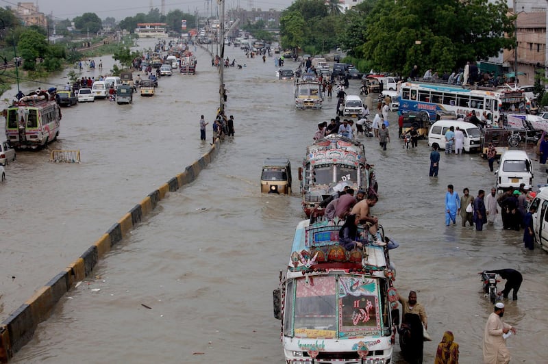 Vehicles drive through a flooded road after heavy monsoon rains, in Karachi, Pakistan. AP