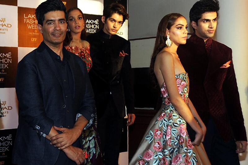 Indian designer Manish Malhotra, left, with models wearing his creations. AFP