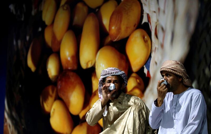 UAE men drink Arabian coffee at Al Dabbas competition on the first day of the Liwa Dates Festival.  EPA