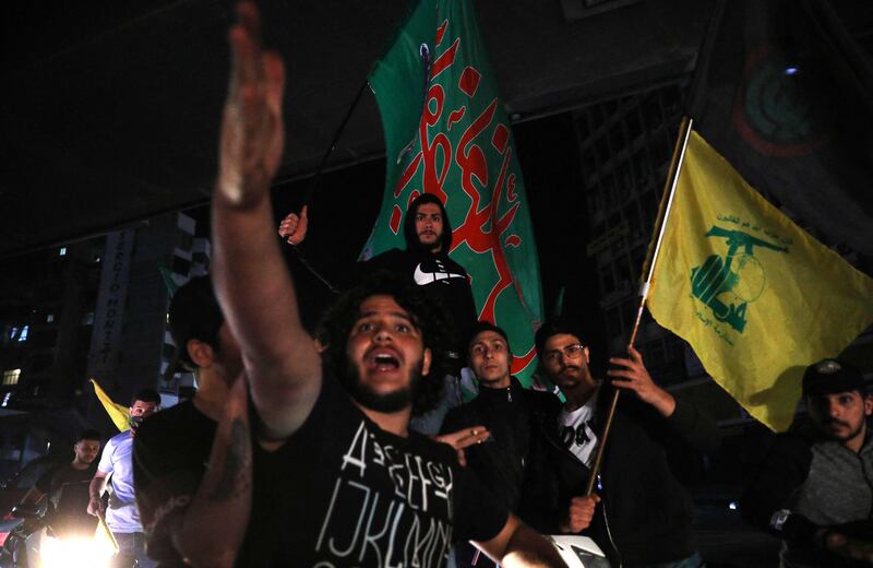 Supporters of Lebanon's Shiite groups Hezbollah and Amal lift their flags during a motorbike rally after voting. AFP