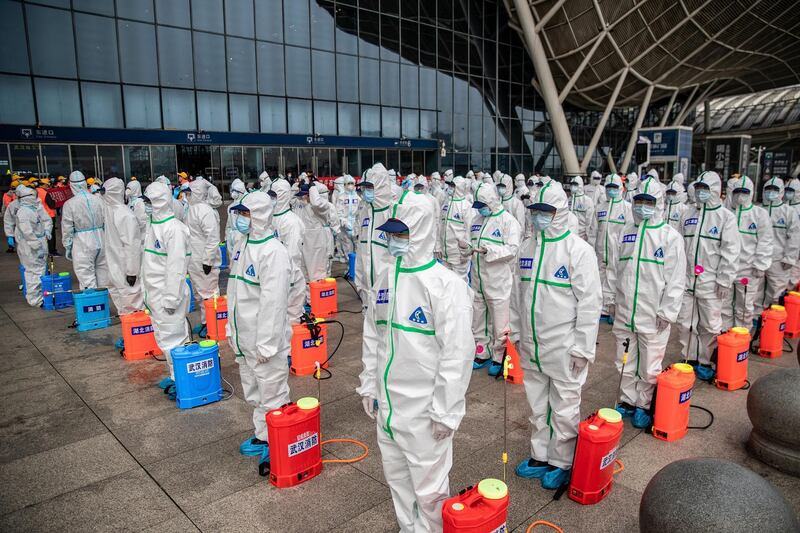 TOPSHOT - Staff members line up at attention as they prepare to spray disinfectant at Wuhan Railway Station in Wuhan in China's central Hubei province on March 24, 2020. - China announced on March 24 that a lockdown would be lifted on more than 50 million people in central Hubei province where the COVID-19 coronavirus first emerged late last year. (Photo by STR / AFP) / China OUT (Photo by STR/AFP via Getty Images)