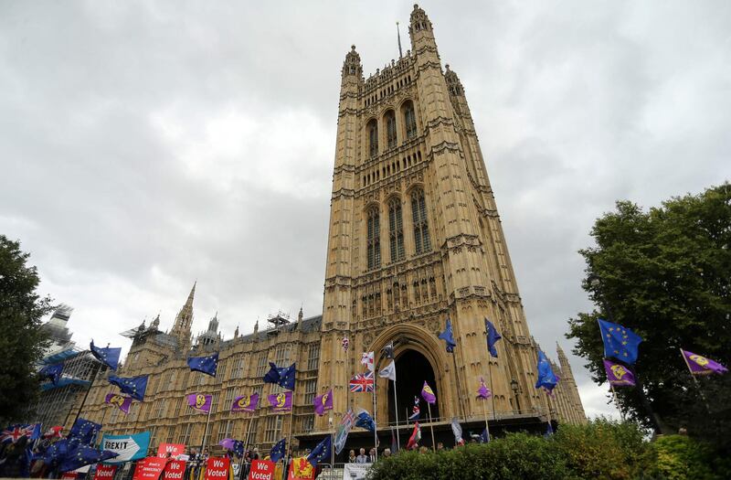 The EU flags of anti-Brexit activists fly as pro-Brexit activists stand with their placards and demonstrate near the Houses of Parliament in central London on September 3, 2019. The fate of Brexit hung in the balance on Tuesday as parliament prepared for an explosive showdown with Prime Minister Boris Johnson's that could end in a snap election. Members of Johnson's own Conservative party, including Philip Hammond, are preparing to join opposition lawmakers in a vote to try to force a delay to Britain's exit from the European Union if he cannot secure a divorce deal with Brussels in the next few weeks. / AFP / ISABEL INFANTES
