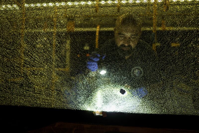 An Israeli security forces member examines a shattered window. Reuters