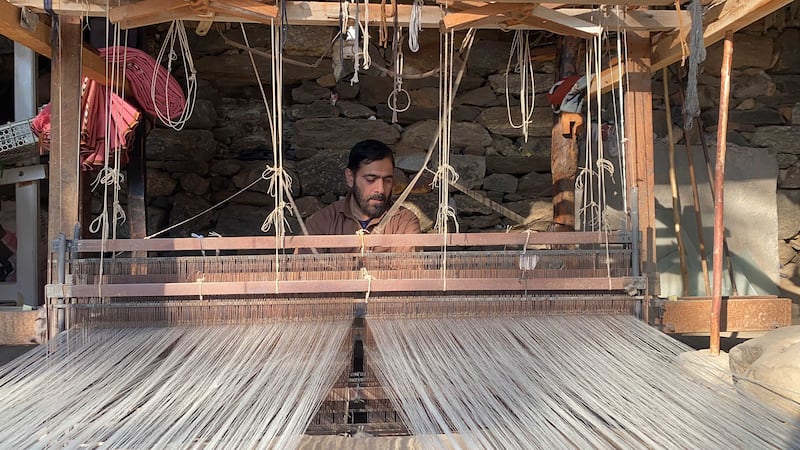 The artisan weaves three shawls a day, which earn him $1.70 apiece