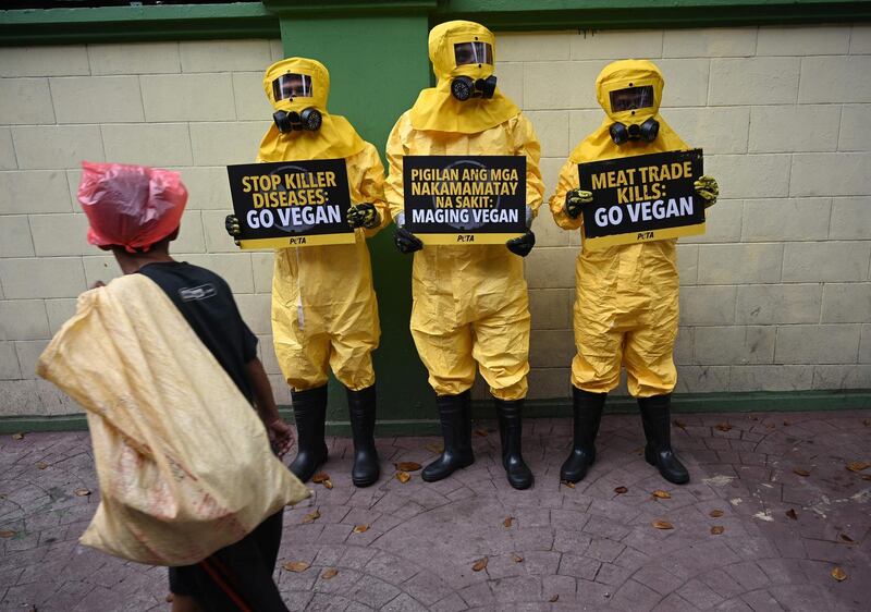 Members of People for the Ethical Treatment of Animals wearing biohazard suits display placards  amidst the COVID-19  scare which has infected thousands of people in China.  AFP