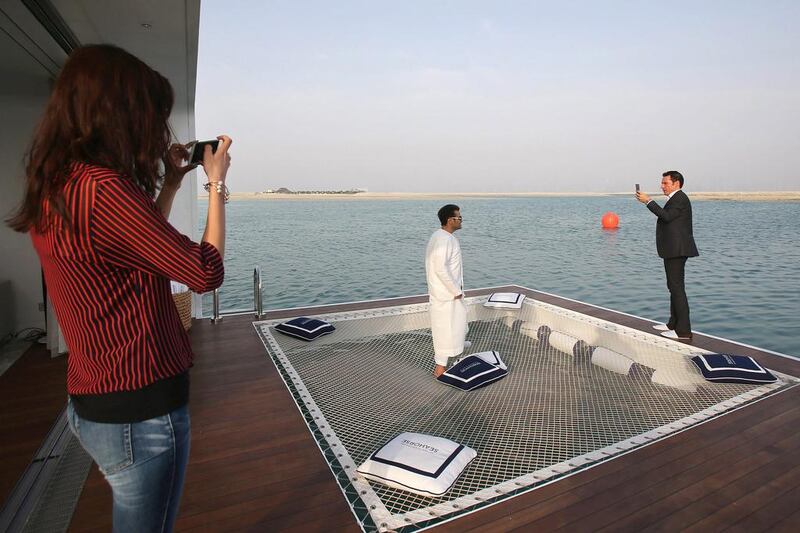 Clients take photos while visiting a full-scale mock-up of the Floating Seahorse home. Kamran Jebreili / AP Photo