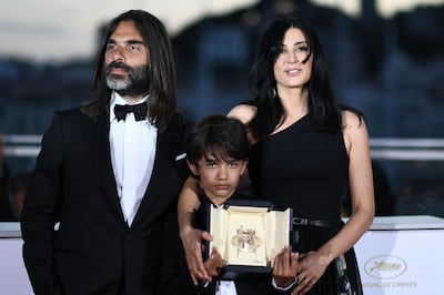 TOPSHOT - Lebanese director and actress Nadine Labaki (R), her husband Lebanese producer Khaled Mouzanar (L) and Syrian actor Zain al-Rafeea pose with the trophy on May 19, 2018 during a photocall after Labaki won the Jury Prize for the film "Capharnaum" at the 71st edition of the Cannes Film Festival in Cannes, southern France.   / AFP / Anne-Christine POUJOULAT            
