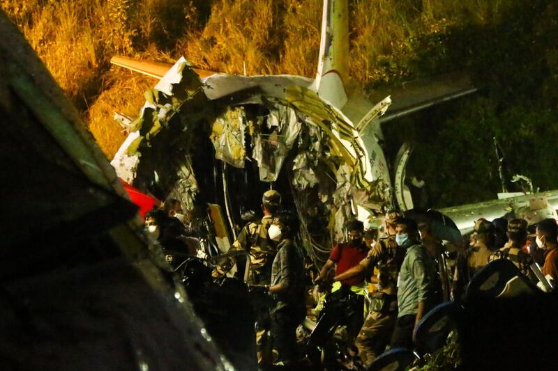 First responders inspect the wreckage of an Air India Express jet, which was carrying more than 190 passengers and crew from Dubai, after it crashed by overshooting the runway at Calicut International Airport in Karipur, Kerala.  AFP