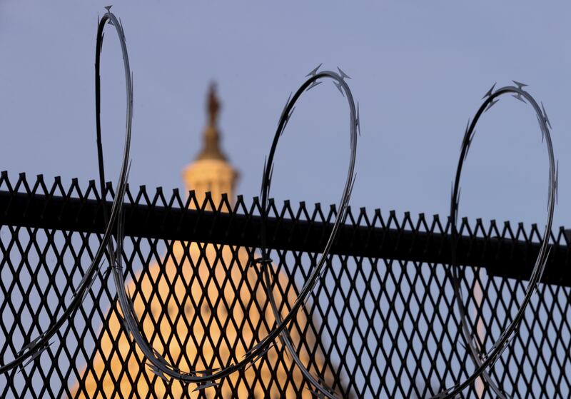 Newly installed razor wire tops the fence surrounding the US Capitol following the January 6 riot. Reuters