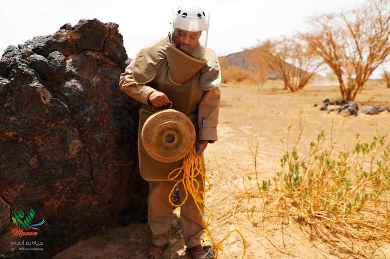 In this undated photograph released Aug. 19, 2018 by the state-run Emirates News Agency (WAM) on behalf of the Saudi-funded Masam anti-mine operation, an unidentified de-miner holds a deactivated mine near Marib, Yemen. Land mines scattered by Yemenâ€™s Houthi rebels will remain a threat even if the latest negotiations succeed in halting the civil war. While the Houthisâ€™ firing of ballistic missiles deep into Saudi Arabia has drawn the most attention, their widespread use of mines within Yemen represents a risk for generations to come in the Arab worldâ€™s poorest country. Yemen is also littered with unexploded cluster munitions and bombs dropped by the Saudi-led coalition, including some made in the United States. (WAM via AP)