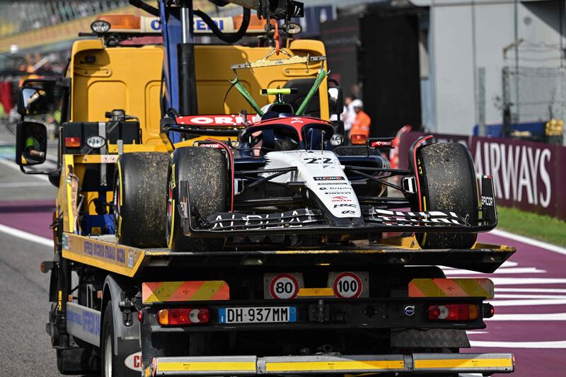 Japanese driver Yuki Tsunoda's Alpha Tauri is towed by a security vehicle after it broke down on the formation lap. AFP