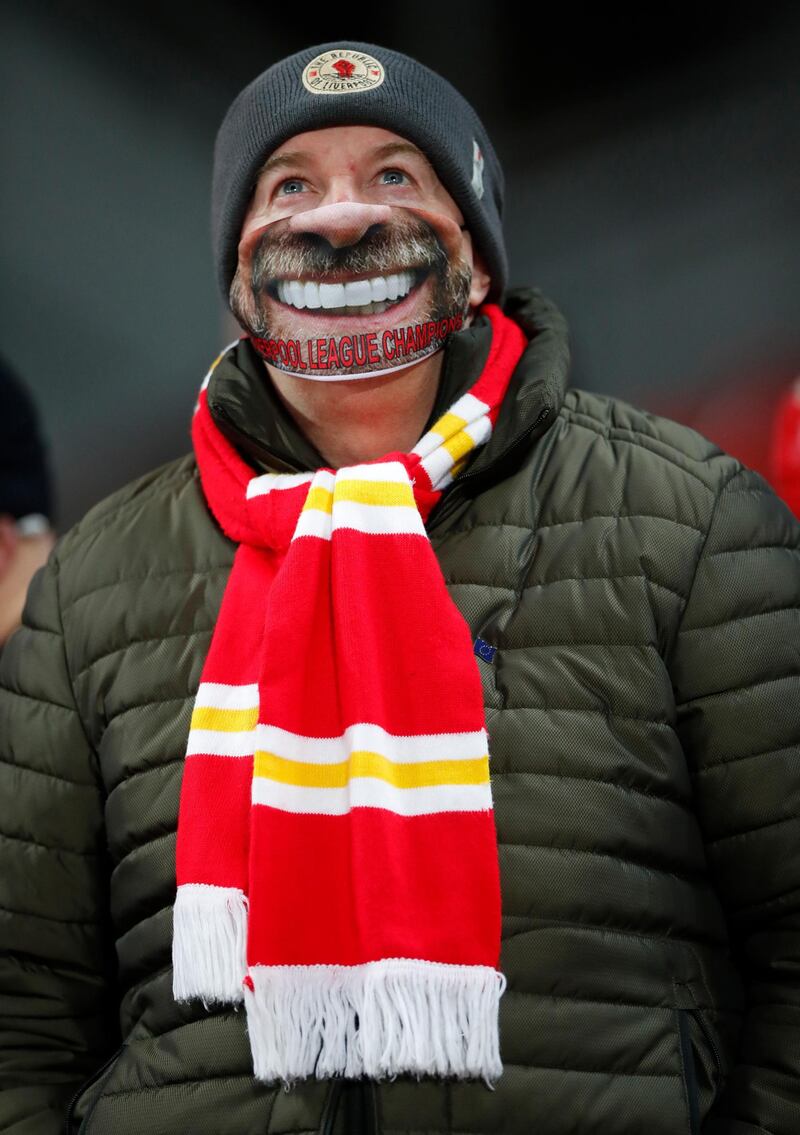 A Liverpool fan wearing a face mask of manager Jurgen Klopp. Reuters