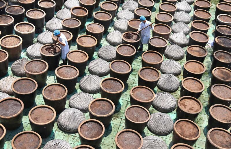 Workers inspect soybean paste at a soy sauce mill in Zibo, Shandong province, China. Reuters