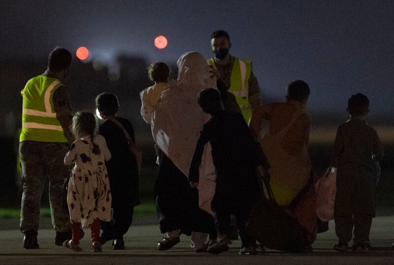 Passengers from Afghanistan disembark from an RAF plane at an airbase in southern England. AFP