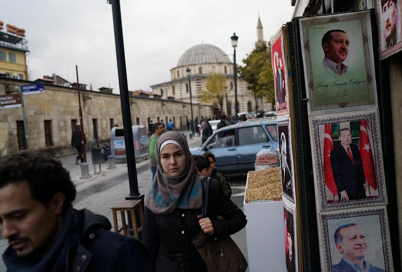 People walk past a shop selling portraits of Turkish President Tayyip Erdogan in Gaziantep, Turkey. Reuters