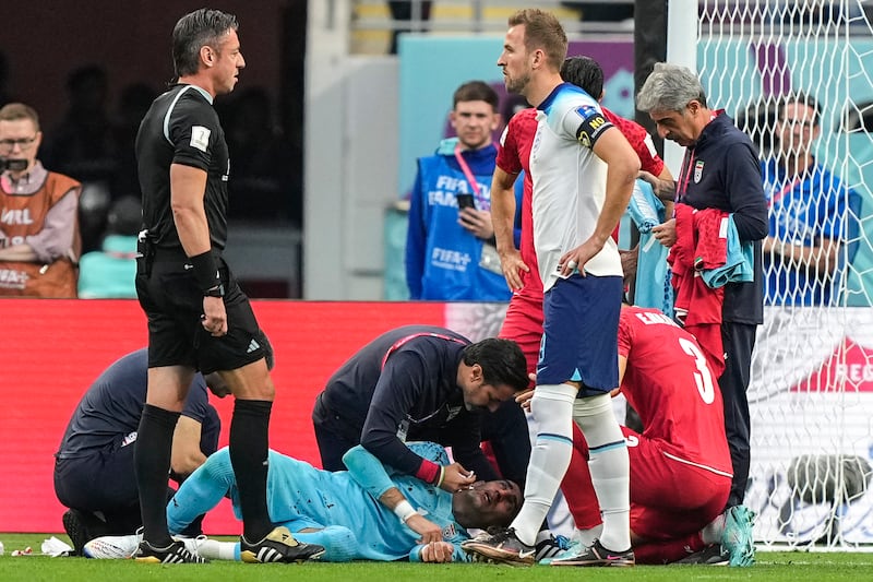Beiranvand, in a blue jersey, lies injured on the ground. Photo: AP