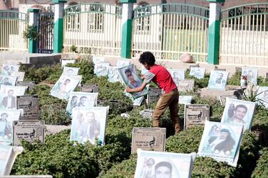 A Yemeni boy holds a picture of his relative at a cemetery dedicated to those who were killed in the country's ongoing conflict, in Sanaa, Yemen, on June 5, 2021. EPA