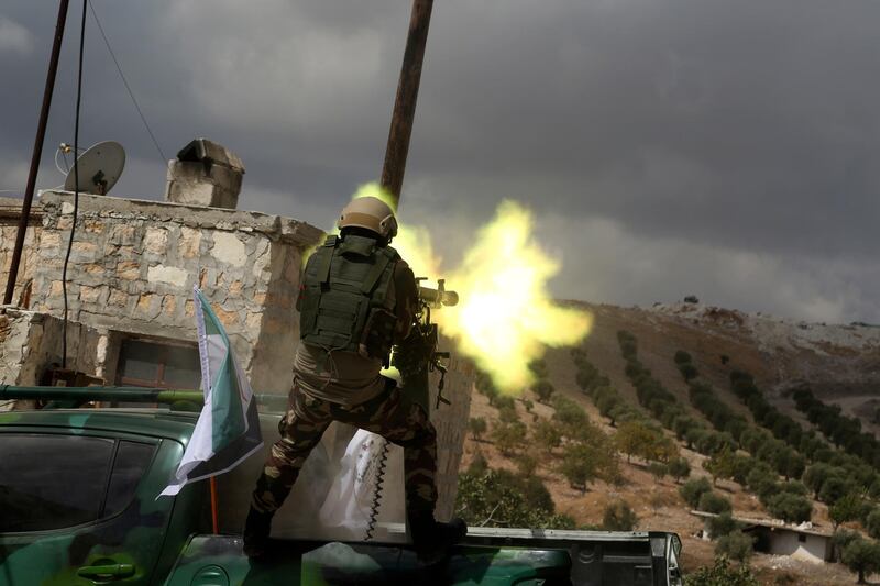 A fighter from Turkish-backed forces of the Free Syrian Army fires a heavy machine gun during military training maneuvers in preparation for an anticipated Turkish incursion targeting Syrian Kurdish fighters, near Azaz, in north Syria. AP Photo