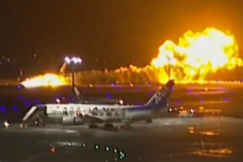 The Japan Airlines plane burns on the runway at Haneda Airport. AP