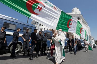 Algerian demonstrators carry a huge national flag in the capital Algiers to protest against the government, in Algeria, Friday, Aug. 16, 2019 (AP Photo/Toufik Doudou)