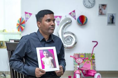 Arunakumar Tavva with a picture of his daughter Devisri, who died of lung disease in 2019, a day before her sixth birthday. Victor Besa / The National
