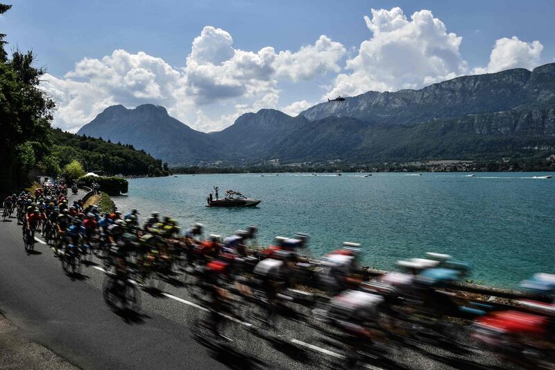 Cyclists ride along the lake of Annecy during the 10th stage of the Tour de France between Annecy and Le Grand-Bornand. Jeff Pachoud / AFP