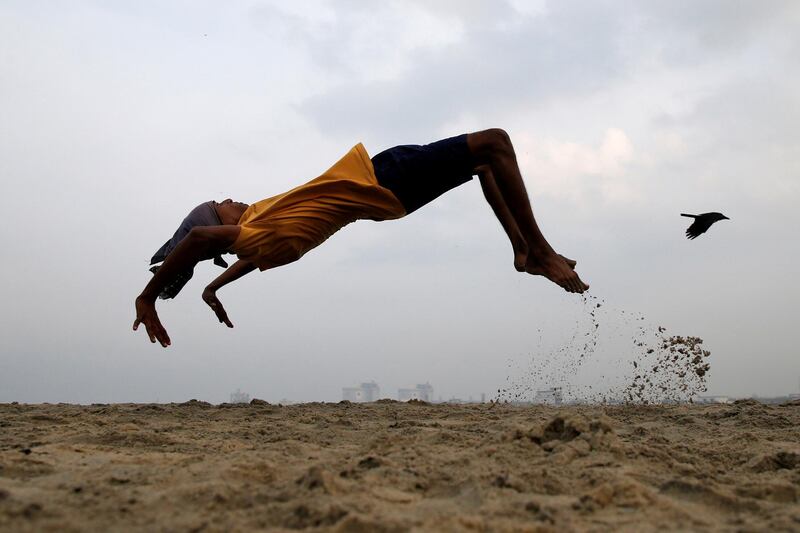 A boy practices somersaulting as he exercises at a beach in Kochi, India. Reuters