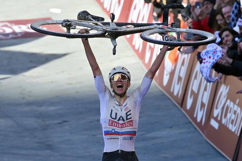 Winner Slovenia's Tadej Pogacar celebrates after crossing the finish line during the men's Strade Bianche' (White Roads) cycling race from and to Siena, Italy, Saturday, March 2, 2024.  (Gian Mattia D'Alberto / LaPresse via AP)
