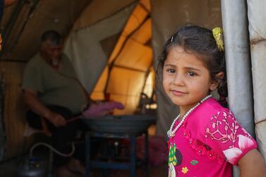 A little girl looks excitedly at the door of a vendor's tent ghazal albnat.