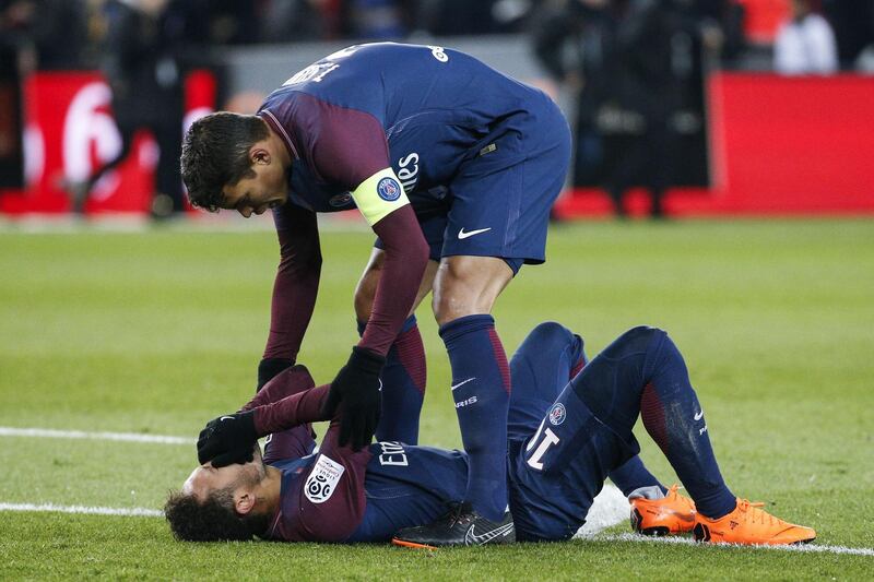 Paris Saint-Germain's Brazilian defender Thiago Silva (up) speaks to Paris Saint-Germain's Brazilian forward Neymar Jr lying on the pitch during the French L1 football match between Paris Saint-Germain (PSG) and Marseille (OM) at the Parc des Princes in Paris on February 25, 2018.  / AFP PHOTO / GEOFFROY VAN DER HASSELT