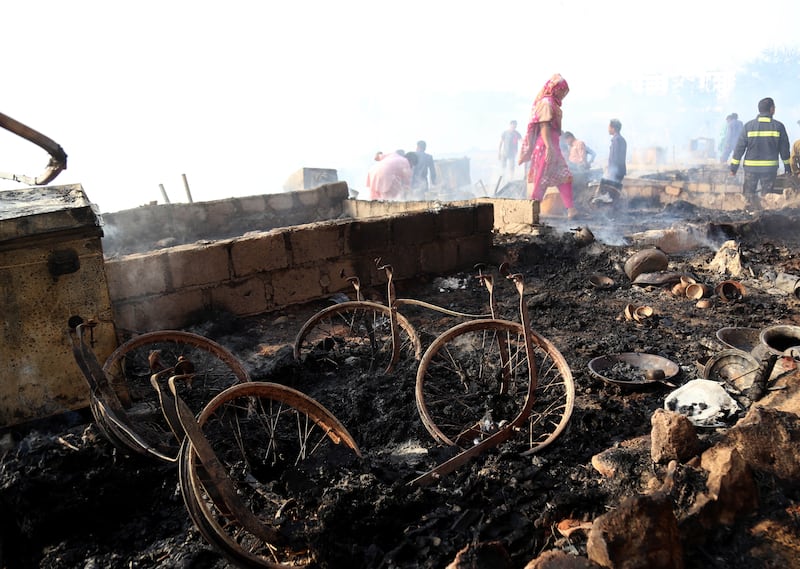 Slum dwellers survey the damage after the blaze. EPA