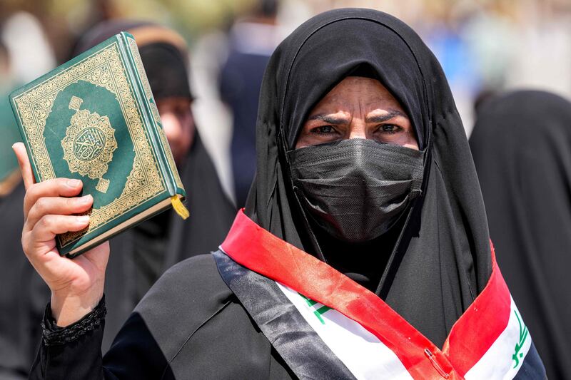A woman holds the Quran in Kufa, Iraq, in protest after an activist desecrated a copy of the holy book for a second time in Sweden. AFP